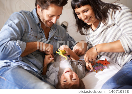 Happy, family and kid playing in living room together for bonding, having fun and entertainment in home. Childhood development, Australian man and woman with child for laughing, joke and toys Happy, family and kid playing in living room together for bonding, having fun and entertainment in home. Childhood development, Australian man and woman with child for laughing, joke and toys 140710558