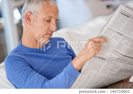 Senior, man and reading a newspaper on sofa for article, information and morning routine in living room of home. Elderly, person and media paper for global news, knowledge or relax on couch in lounge Senior, man and reading a newspaper on sofa for article, information and morning routine in living room of home. Elderly, person and media paper for global news, knowledge or relax on couch in lounge 140710601
