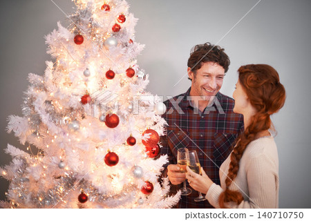 Couple, Christmas and tree with champagne for celebration together for festive season or holiday vacation, decoration or lights. Man, woman and drinking alcohol in home or happy event, love or gifts Couple, Christmas and tree with champagne for celebration together for festive season or holiday vacation, decoration or lights. Man, woman and drinking alcohol in home or happy event, love or gifts 140710750