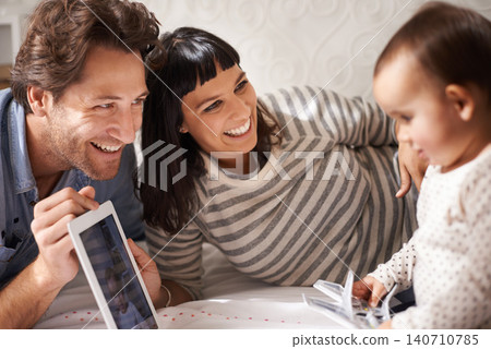Parents, toddler and tablet for entertainment in home, online and happy for education in bedroom. Family, child development and girl for streaming on internet, website and app for cartoon or movie Parents, toddler and tablet for entertainment in home, online and happy for education in bedroom. Family, child development and girl for streaming on internet, website and app for cartoon or movie 140710785