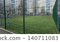 Empty outdoor soccer field with artificial grass and green fence in a residential urban area. 140711083