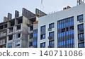 Adult Caucasian male worker in safety vest works on high-rise residential building site. 140711086