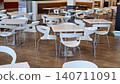 Empty modern restaurant interior features white designer chairs and square tables with no people. 140711091