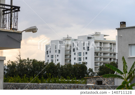 Modern architecture stands against a cloudy sky in a serene urban landscape Modern architecture stands against a cloudy sky in a serene urban landscape 140711128