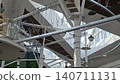 An empty indoor rope course for diverse users of all ages and genders with metal beams and safety gear. 140711131
