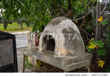 Outdoor stone oven surrounded by greenery on a sunny day in a tranquil setting Outdoor stone oven surrounded by greenery on a sunny day in a tranquil setting 140711188