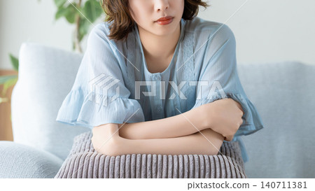 A woman sitting on a sofa and thinking A woman sitting on a sofa and thinking 140711381
