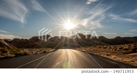 Desert Road Toward Bright Sun with Dramatic Sunburst and Long Shadows in Nevada Desert Road Toward Bright Sun with Dramatic Sunburst and Long Shadows in Nevada 140711953