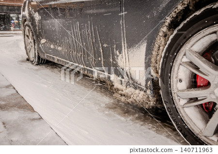 Snow Covered Car Tire and Dirty Vehicle After Winter Storm Driving Conditions on Slushy Road Surface Snow Covered Car Tire and Dirty Vehicle After Winter Storm Driving Conditions on Slushy Road Surface 140711963