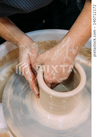 Artistic occupation. Creative earthenware. Unrecognizable professional woman hands master working with clay pot in artisan workplace. Artistic occupation. Creative earthenware. Unrecognizable professional woman hands master working with clay pot in artisan workplace. 140712172