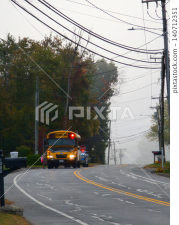 Yellow School Bus Traveling Along Quiet Rainy Suburban Morning Road Yellow School Bus Traveling Along Quiet Rainy Suburban Morning Road 140712351
