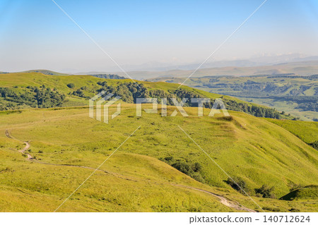 Layers of green mountains and hills in the haze during sunset. Panoramic View of Green hills and Meadow. 140712624