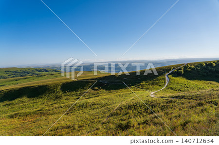 Layers of green mountains and hills in the haze during sunset. Panoramic View of Green hills and Meadow. Layers of green mountains and hills in the haze during sunset. Panoramic View of Green hills and Meadow. 140712634