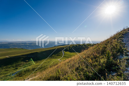 Layers of green mountains and hills in the haze during sunset. Panoramic View of Green hills and Meadow. Layers of green mountains and hills in the haze during sunset. Panoramic View of Green hills and Meadow. 140712635