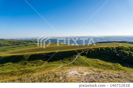 Layers of green mountains and hills in the haze during sunset. Panoramic View of Green hills and Meadow. Layers of green mountains and hills in the haze during sunset. Panoramic View of Green hills and Meadow. 140712638