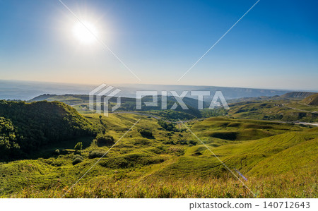 Layers of green mountains and hills in the haze during sunset. Panoramic View of Green hills and Meadow. Layers of green mountains and hills in the haze during sunset. Panoramic View of Green hills and Meadow. 140712643