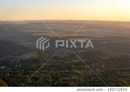 Layers of green mountains and hills in the haze during sunset. Panoramic View of Green hills and Meadow. 140712659