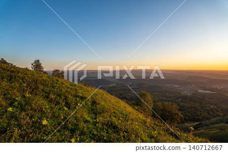 Layers of green mountains and hills in the haze during sunset. Panoramic View of Green hills and Meadow. Layers of green mountains and hills in the haze during sunset. Panoramic View of Green hills and Meadow. 140712667