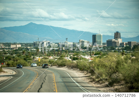Tucson Arizona Skyline with Downtown Buildings and Mountain Backdrop Viewed from Desert RoadApproach Tucson Arizona Skyline with Downtown Buildings and Mountain Backdrop Viewed from Desert RoadApproach 140712786