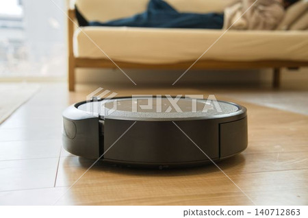 一個人正在和掃地機器人一起放鬆。 一個人正在和掃地機器人一起放鬆。 140712863