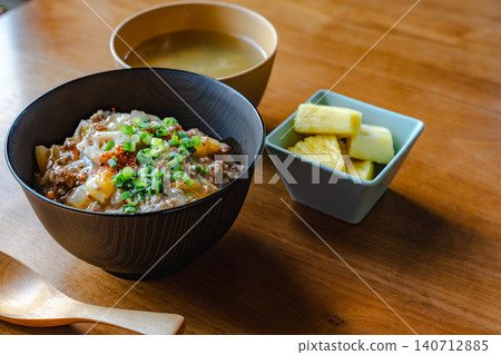A Japanese meal set featuring a warm wooden spoon and a beef bowl. A Japanese meal set featuring a warm wooden spoon and a beef bowl. 140712885