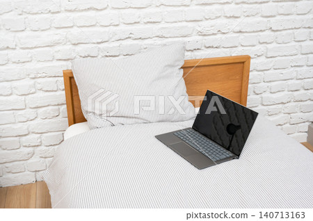 一間白色房間,裡面有一台筆記型電腦和一張床。 一間白色房間,裡面有一台筆記型電腦和一張床。 140713163