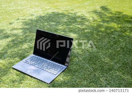 Laptop placed on the grass Laptop placed on the grass 140713171