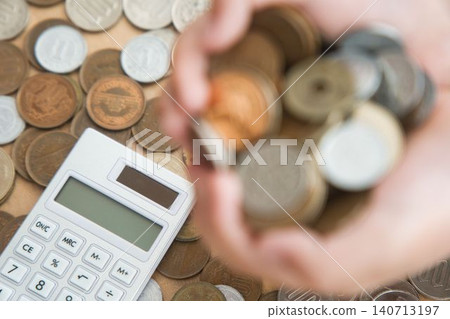 一台計算器,旁邊放著硬幣,畫面清晰可見。 一台計算器,旁邊放著硬幣,畫面清晰可見。 140713197