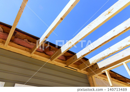 Workers on wooden framework of house roof during building roof trusses frame Workers on wooden framework of house roof during building roof trusses frame 140713489