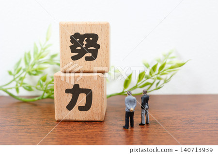 The word "effort." A miniature businessman figure and wooden blocks. Skill improvement. 140713939