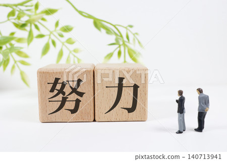 “努力”一詞。一個迷你商人模型和木製積木。技能提升。 140713941