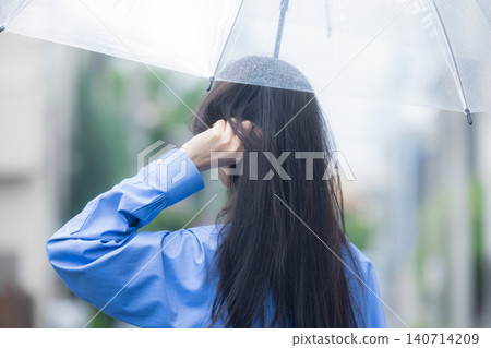 A young woman holding an umbrella in the rain 140714209