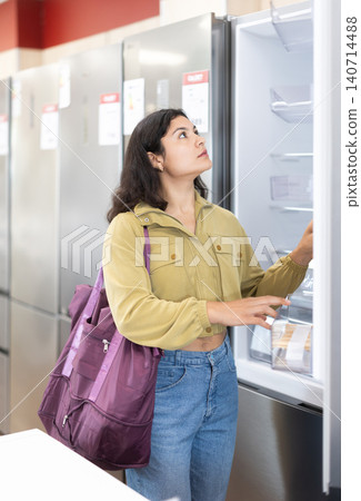 Woman is shopping in a store - choosing new fridge in supermarket Woman is shopping in a store - choosing new fridge in supermarket 140714488