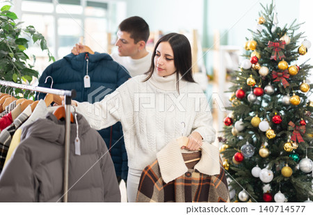 Couple customer choose jacket or coat for girl, New Year atmosphere 140714577