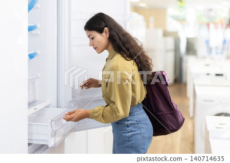 Young woman choosing fridge at household appliances store Young woman choosing fridge at household appliances store 140714635