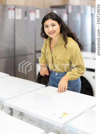 Latina woman came to a modern home appliance store, she choose a washing machine 140714656