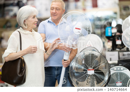 Elderly couple choose fan together at hardware store Elderly couple choose fan together at hardware store 140714664