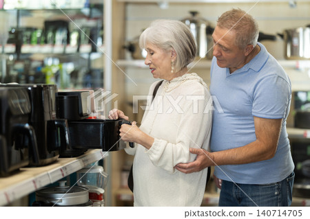 Married couple chooses best coffee machine together at supermarket Married couple chooses best coffee machine together at supermarket 140714705