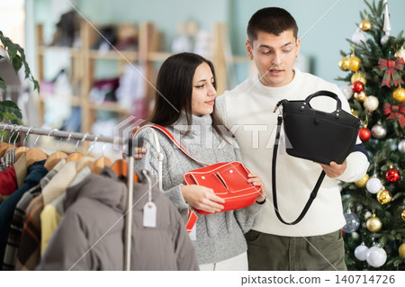 Young couple chooses handbag in store Young couple chooses handbag in store 140714726