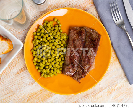 Grilled veal steak with vegetable garnish of canned green peas. Healthy dinner concept Grilled veal steak with vegetable garnish of canned green peas. Healthy dinner concept 140714753