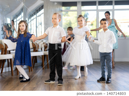 Tween boys and girls bowing and curtsying at Christmas dance event at school Tween boys and girls bowing and curtsying at Christmas dance event at school 140714803