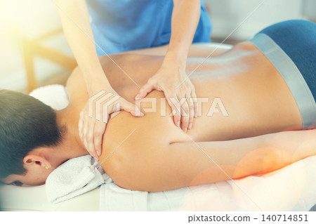 Close up of woman hands of massager woman doing massage to young man in spa salon Close up of woman hands of massager woman doing massage to young man in spa salon 140714851