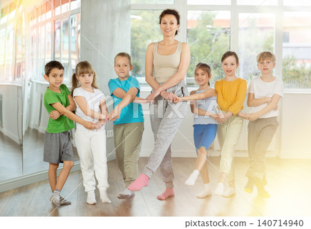 Preteen children and doing cancan dance together with female trainer 140714940