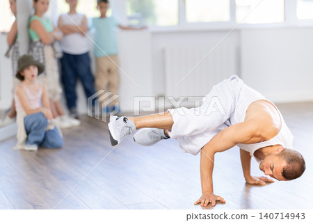 Hip-hop instructor dancing in front of preteen students in studio Hip-hop instructor dancing in front of preteen students in studio 140714943