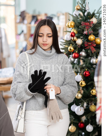 Young girl choosing gloves in clothing store Young girl choosing gloves in clothing store 140715036