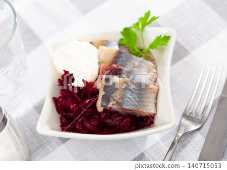 Pickled herring slices with grated beets, mayonnaise and fresh parsley 140715053