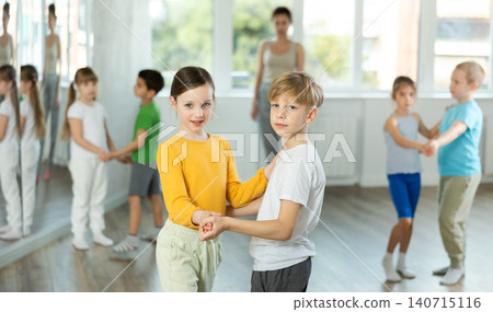 Girl paired up with boy and training to perform slow couple dance, rehearse performance. Girl paired up with boy and training to perform slow couple dance, rehearse performance. 140715116