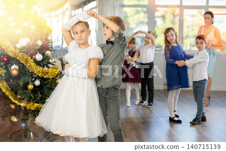 Little children practicing waltz dance in school-hall decorated with Christmas-tree Little children practicing waltz dance in school-hall decorated with Christmas-tree 140715139