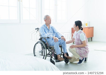 Caregivers who support elderly people in wheelchairs Caregivers who support elderly people in wheelchairs 140715294