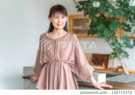 Middle-aged business woman in the kitchen or dining room Middle-aged business woman in the kitchen or dining room 140715578
